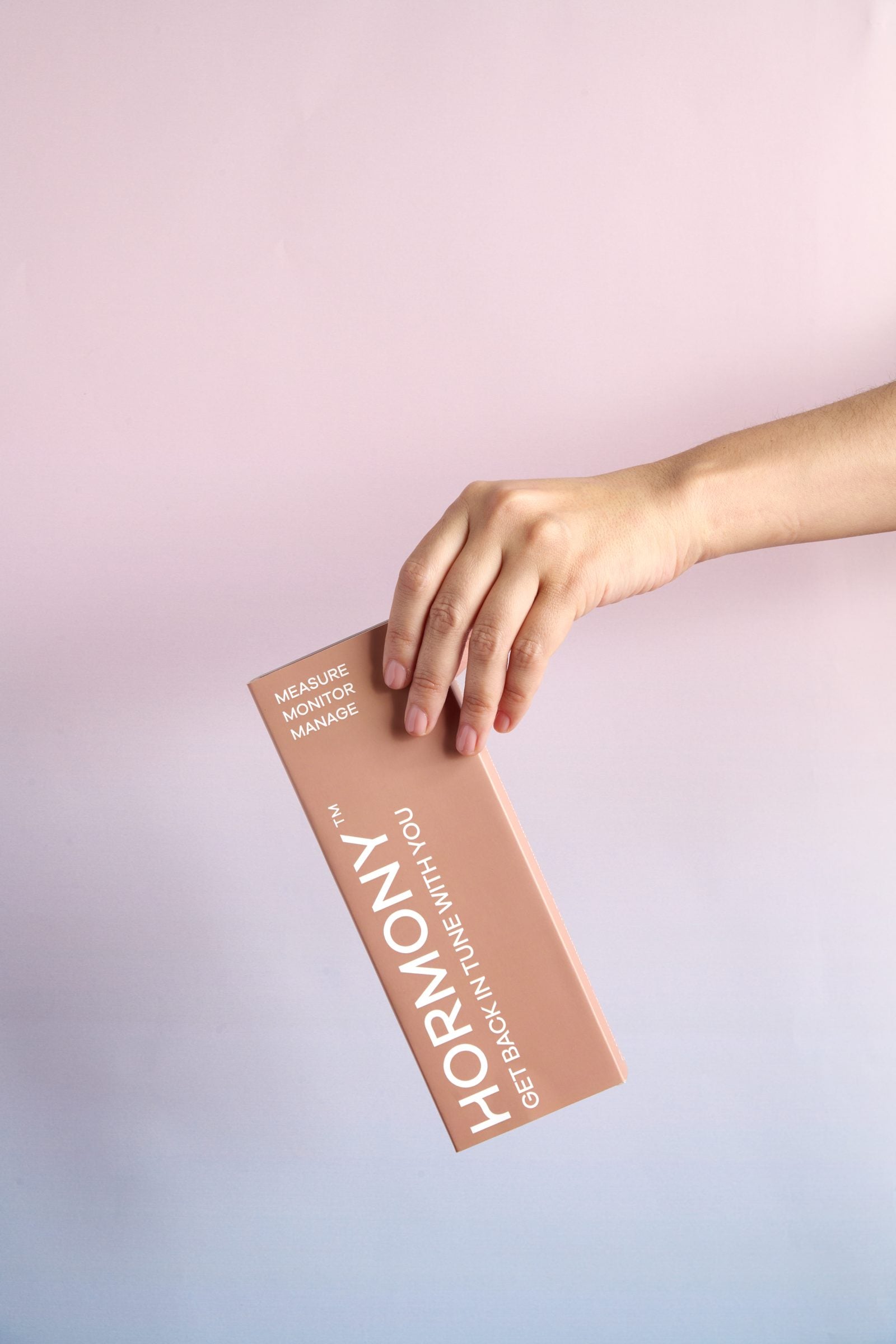 Hormony® Cortisol Rhythm At Home Rapid Saliva Test Kit — the coral box held against a soft pink and lavender background