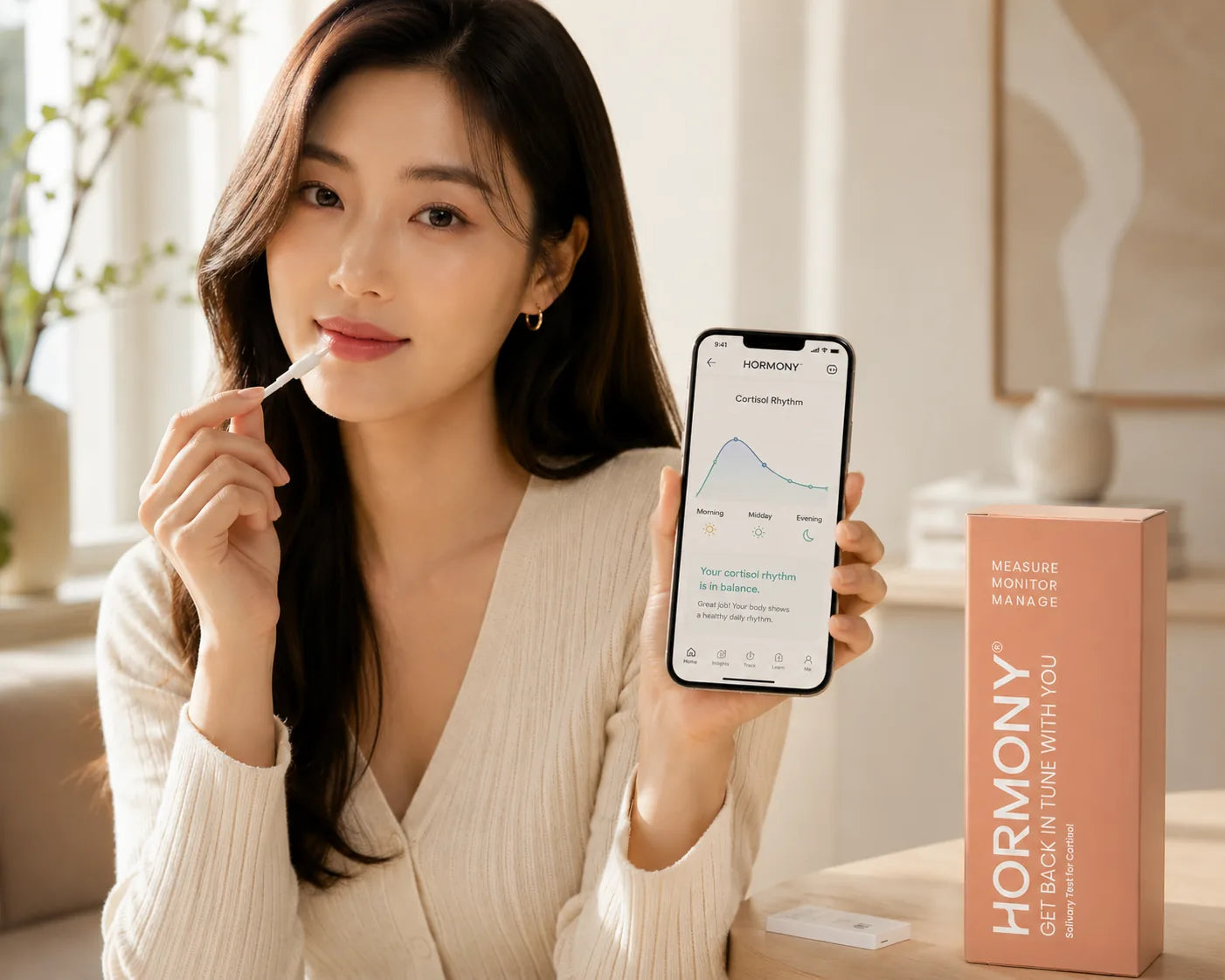Woman using the Hormony® saliva collection swab while holding a phone displaying her cortisol results in the app