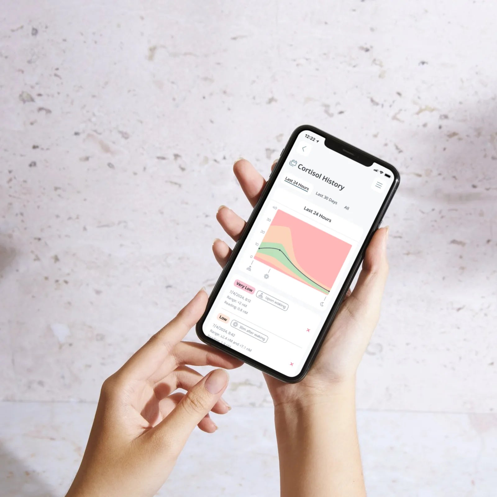 Hands holding a phone scanning a Hormony® test strip using the app