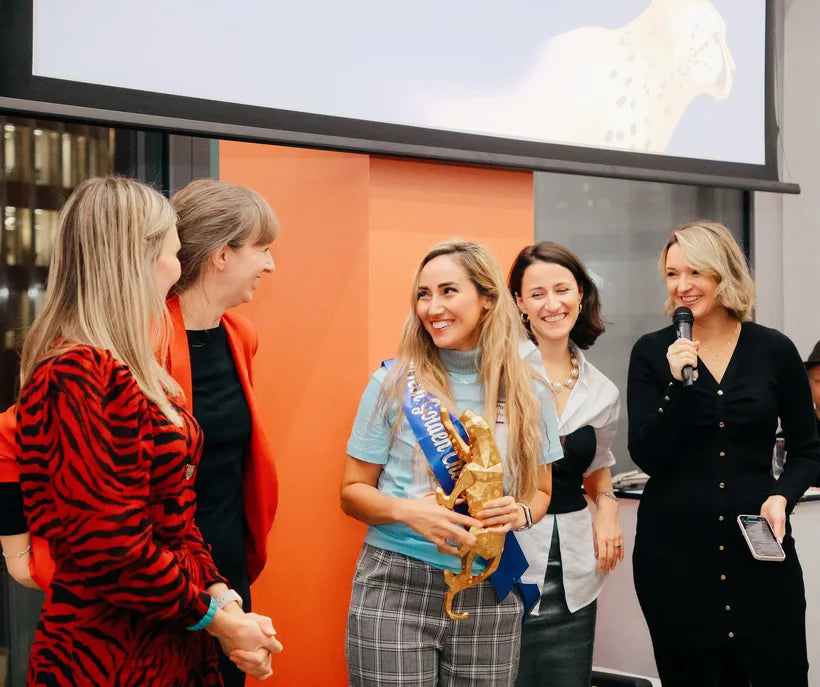 Hormony's founder holding the FemTech Lab Golden Cheetah Award among colleagues
